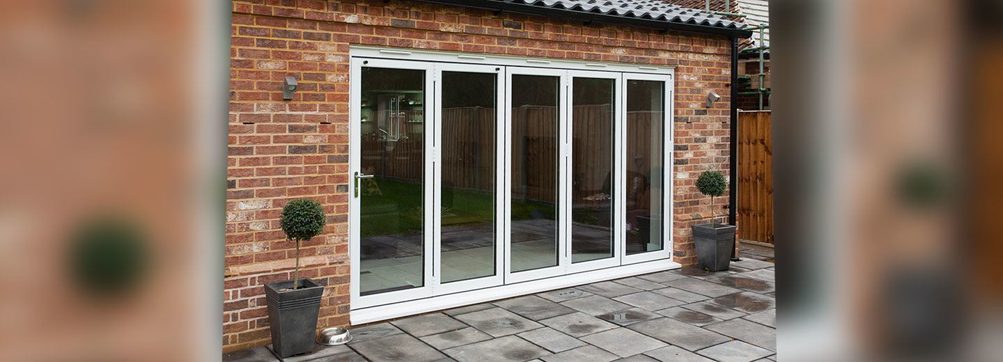 Contemporary white aluminium sliding doors opening onto a garden